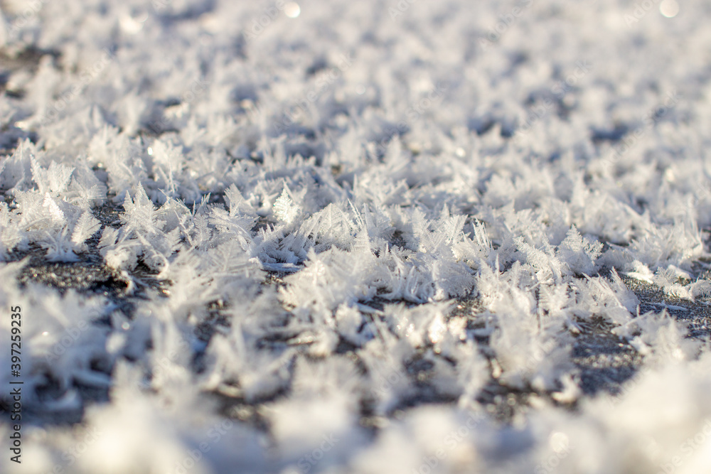 Obraz premium Ice crystals and white snowflakes near the water in winter.