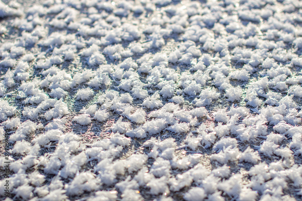 Obraz premium Ice crystals and white snowflakes near the water in winter.