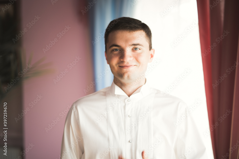 Beautiful man, groom posing and preparing for wedding