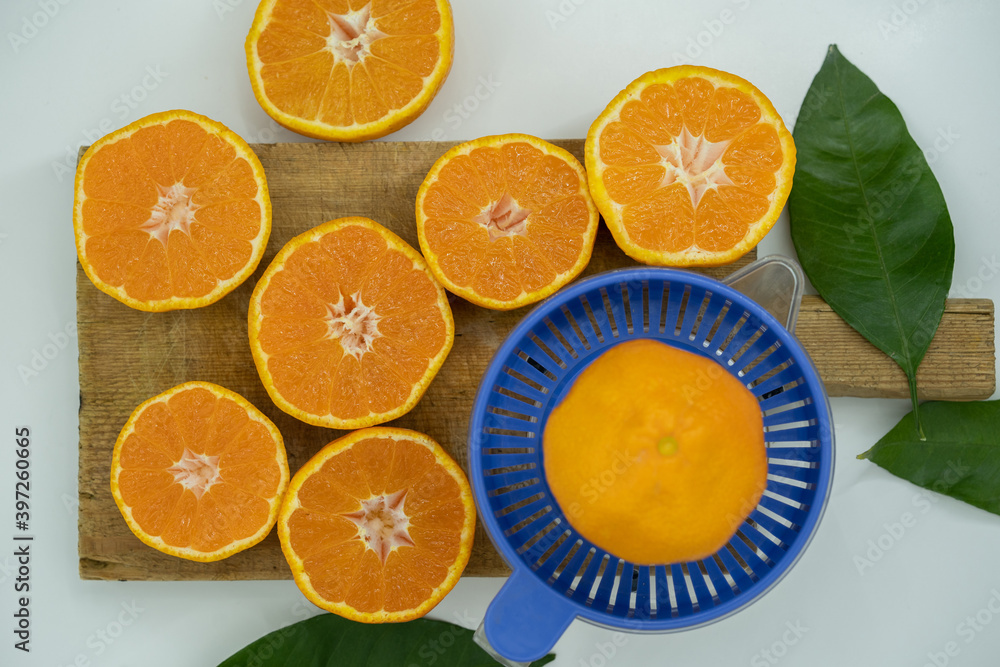 Delicious fresh squeezed tangerine juice in a transparent glass. Peeled sliced mandarin orange close up pieces. Delicious fresh squeezed tangerine juice in a transparent glass. Peeled sliced mandarin orange close up pieces.