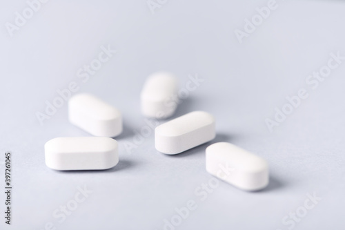 Carnitine tablets. Concept for a healthy dietary supplementation. Bright paper background. Soft focus. Close up.