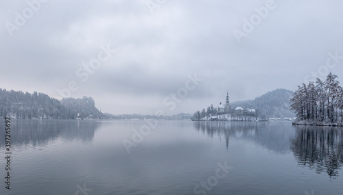 Fototapeta Naklejka Na Ścianę i Meble -  Bled lake in wintertime, scenic view of Bled Island in snow and fog, Slovenia.