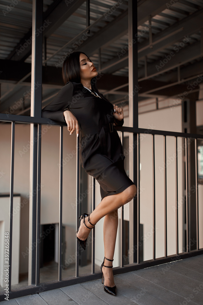 Girl in fashionable black casual clothes on a background of a stone wall, modern urban architecture, vogue style photo Girl in fashionable black casual clothes on a background of a stone wall, modern urban architecture, vogue style photo
