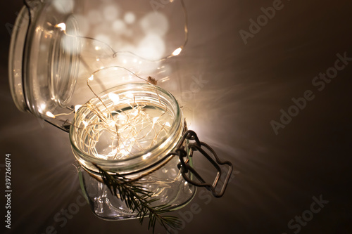 Glass jar with a garland inside in the dark. New Year and Christmas concept.