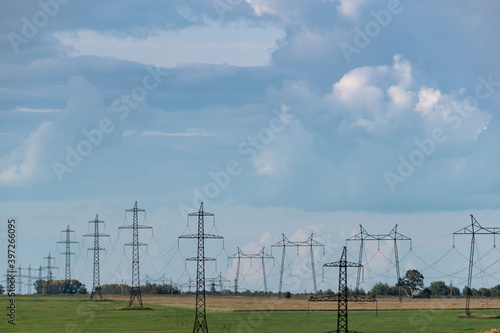 Farm field with power lines on horizon. Energy transportation