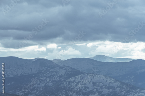Thick clouds over mountain range, hills in blue haze
