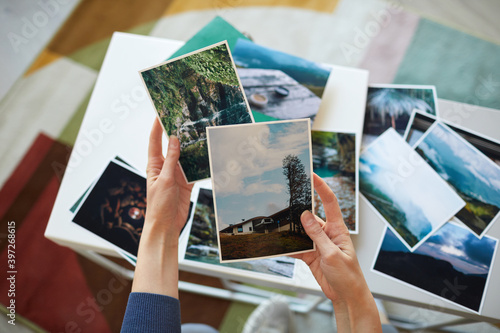 Close-up of woman holding photos in her hands remembering her best moments photo