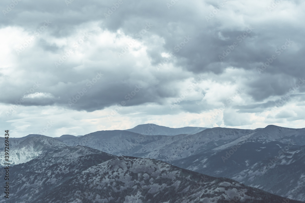 Obraz premium Scenic view of misty mountain valley. Gentle hills under overcast clouds.