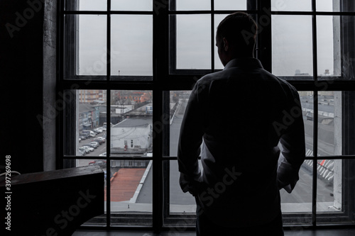Man looking out the window. Businessman. Industrial. From window