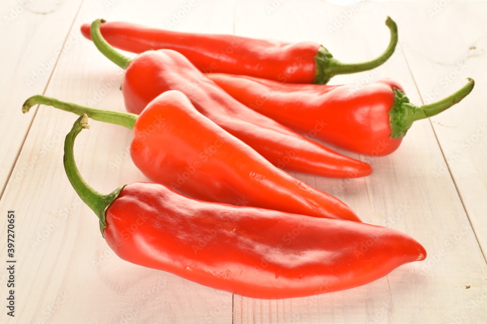 Several ripe organic tasty sweet Kapia peppers on a  wood background.