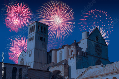 Celebratory fireworks for new year over Saint Francesco of Assisi church or cathedral or basilica in Italy during last night of year. Christmas blue atmosphere 