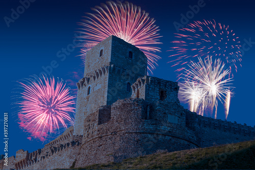 Celebratory fireworks for new year over rocca maggiore in assisi, a medival tower up a hill during last night of year. Christmas atmosphere  photo