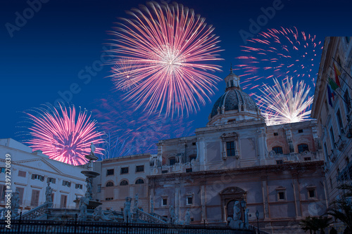 Celebratory fireworks for new year over pretoria baroque fountain in Palermo, Italy during last night of year. Christmas blue atmosphere 