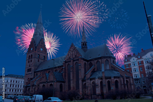 Celebratory fireworks for new year over St. or Saint Peters or Petri Church in Malmo - Sweden during last night of year. Christmas atmosphere