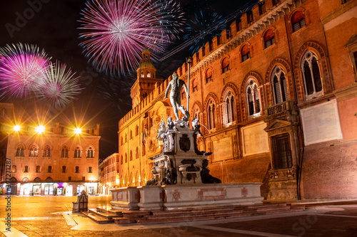Celebratory fireworks for new year over Neptune statue in Bologna during last night of year. Christmas atmosphere