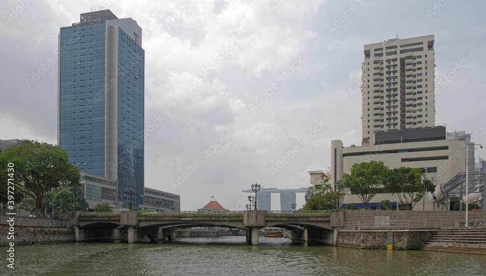 View of the Coleman Bridge on the Singapore River. On the bridge, pedestrians, on the river ship View of the Coleman Bridge on the Singapore River. On the bridge, pedestrians, on the river ship