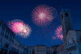 Celebratory fireworks for new year over Paul VI place or square in Brescia, Italy during last night of year. Christmas atmosphere. There is the saint maria assunta old romanic stone bricks cathedral 