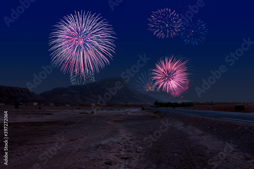 Celebratory fireworks for new year over the moroccon desert near ouarzazate  during last night of year. Christmas atmosphere.  Street or road in close up and mountain in background