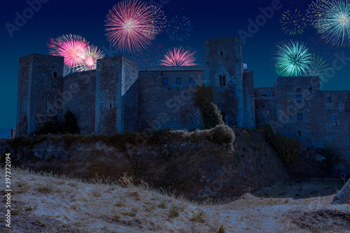 Celebratory fireworks for new year over Melfi's castle, a medieval stone bricks castle in south of italy in Basilicata during last night of year. Christmas atmosphere