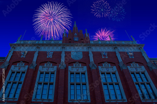 Celebratory fireworks for new year over Collegium Novum in Krakow or Cracow - Poland during last night of year. Christmas atmosphere.  photo