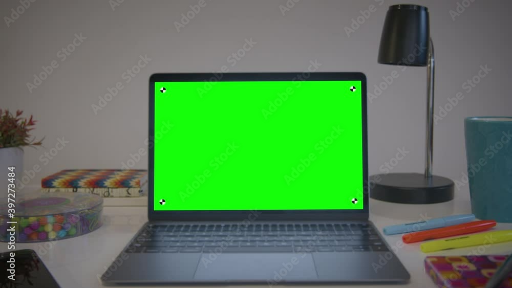 Home office setup, computer monitor with chroma key. Dolly in shot of laptop with green screen on a white desk. Perfect to put your own images or videos. Track points with perspective corner pin. Home office setup, computer monitor with chroma key. Dolly in shot of laptop with green screen on a white desk. Perfect to put your own images or videos. Track points with perspective corner pin.