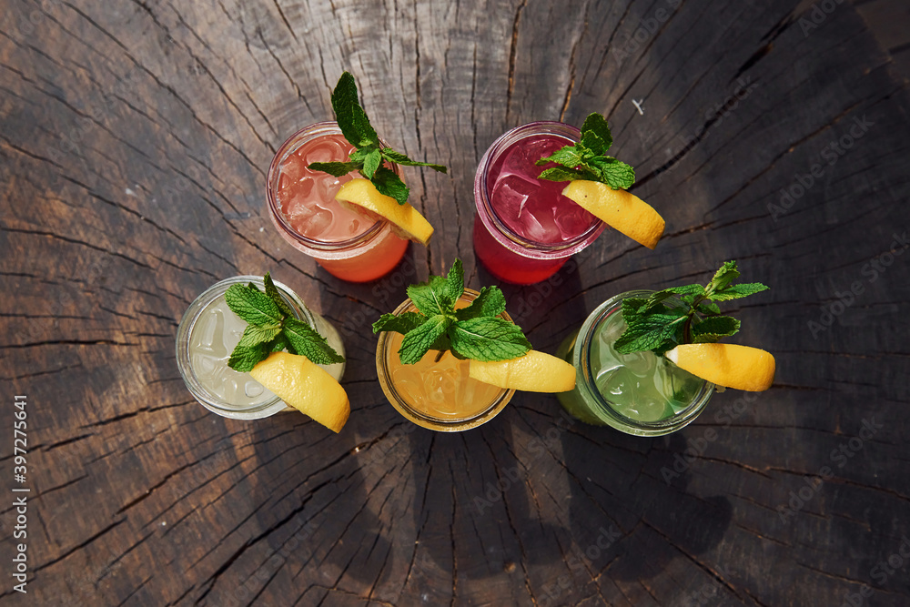 Yellow and green colored. Close up view of fresh summer alcoholic cocktails on the wooden table