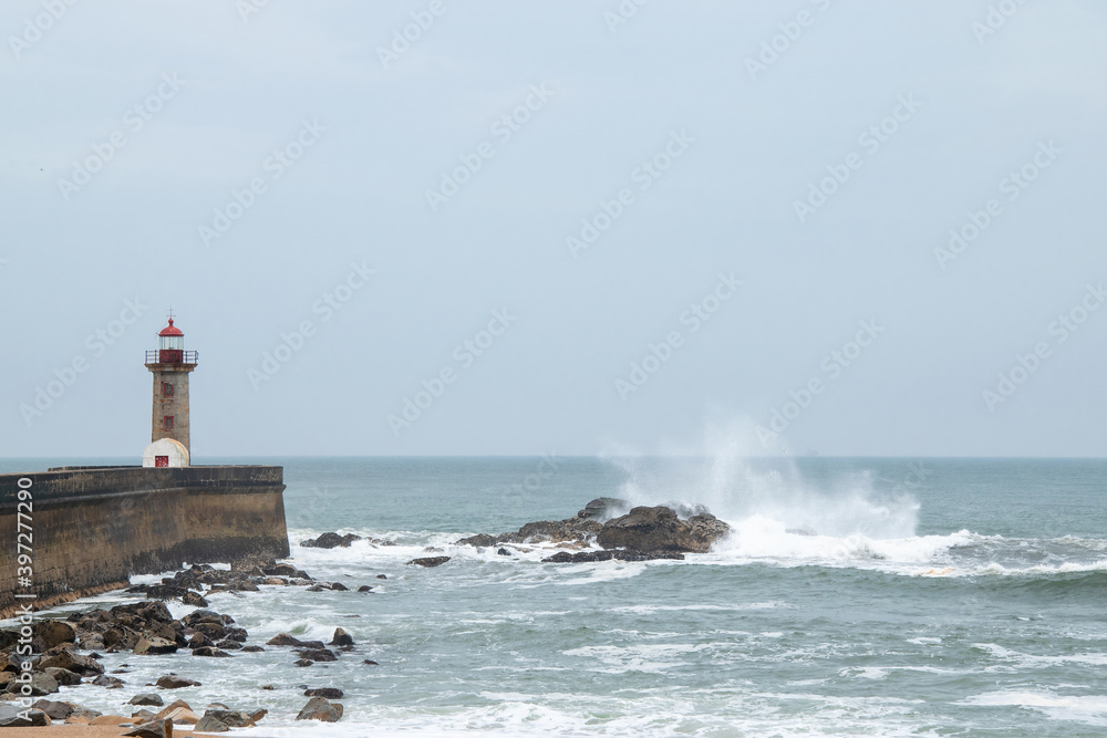 Coastline of Atlantic ocean. Rainy day and waves. Historical Felgueiras Lighthouse built on 1886 in Foz do Douro near from Porto, Portugal