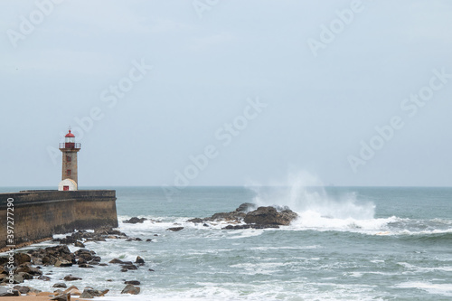 Coastline of Atlantic ocean. Rainy day and waves. Historical Felgueiras Lighthouse built on 1886 in Foz do Douro near from Porto, Portugal