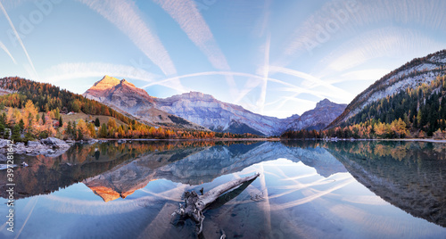 Spectacular scenery of lake with smooth surface reflecting amazing mountain range and sky photo