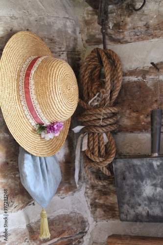 straw hat and rope hanging on wall in old house