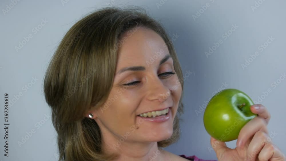Face portrait of a young beautiful woman holding big green apples in her hands, smiling thoughtfully. The concept of vegan and diet, fresh fruits in the hands of a young girl, healthy food. Face portrait of a young beautiful woman holding big green apples in her hands, smiling thoughtfully. The concept of vegan and diet, fresh fruits in the hands of a young girl, healthy food.