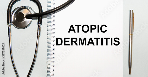 In the notebook is the text OF ATOPIC DERMATITIS, next to the stethoscope and pen.
