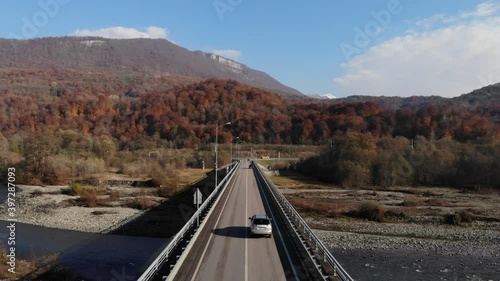 aerial view of a cars riding on a bridge over a river, shooting from a drone. Cinematic 4K aerial footage.