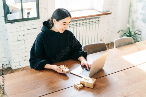 young asian girl buying christmas presents in online shopping, sales and discounts promotions during the Christmas holidays, online shopping at home and lockdown coronavirus.Xmas