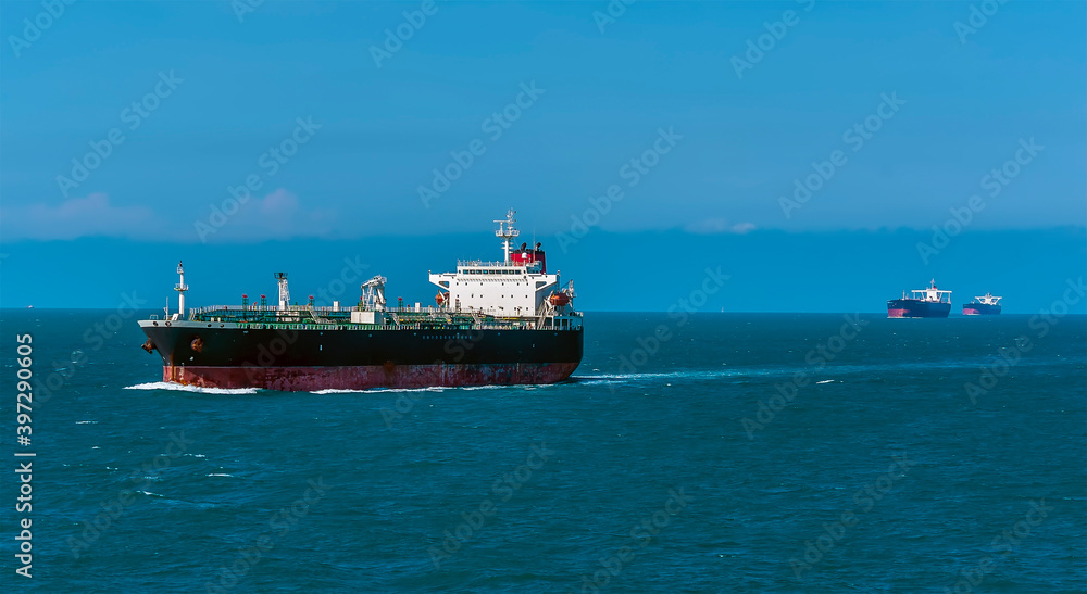 Tankers sailing along a channel in the Singapore Straits in Asia in summertime Tankers sailing along a channel in the Singapore Straits in Asia in summertime
