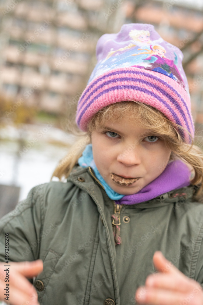 Kinder/Jugendlich leiden wegen der Corona-Covid-19 Pandemie unter dem Lockdown. Das Mädchen ist einsam und allein auf dem Kinderspielplatz. Nur zum Naschen darf sie im Park den Mundschutz abnehmen. Kinder/Jugendlich leiden wegen der Corona-Covid-19 Pandemie unter dem Lockdown. Das Mädchen ist einsam und allein auf dem Kinderspielplatz. Nur zum Naschen darf sie im Park den Mundschutz abnehmen.