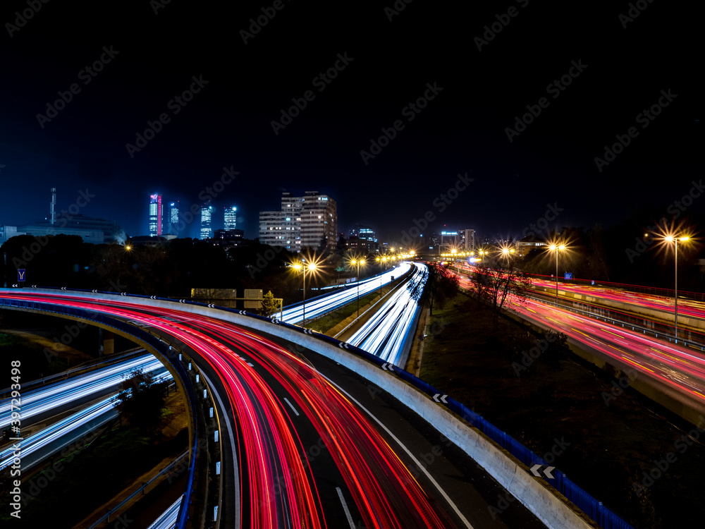 Light trails produced at dusk by the headlights and tail lights of cars from a bridge Light trails produced at dusk by the headlights and tail lights of cars from a bridge