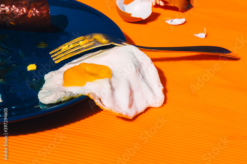 Fried egg spiling over plate photo