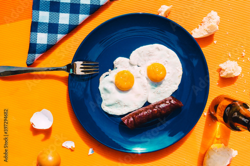 Bottle of beer and plate with fried eggs and chorizo photo