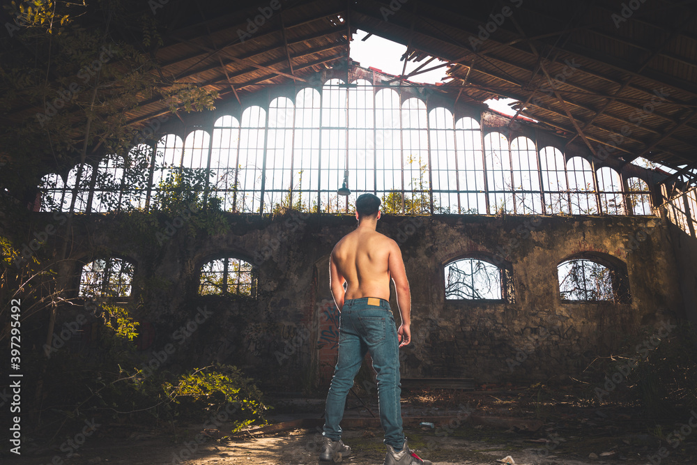 Shirtless handsome young man posing at the old train station.