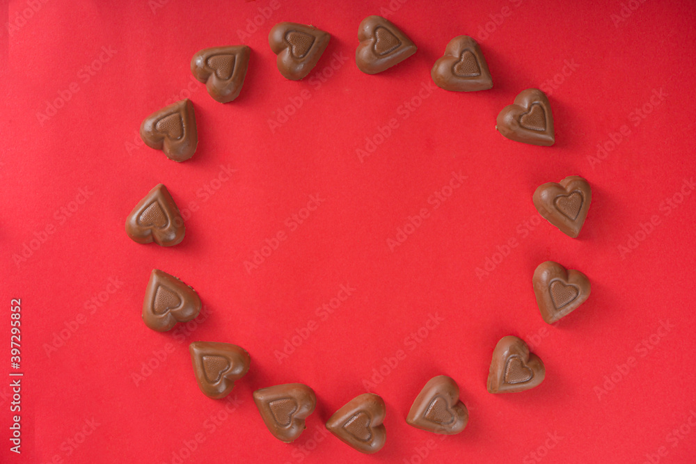 Chocolate hearts frame over red background top view copy space Chocolate hearts frame over red background top view copy space