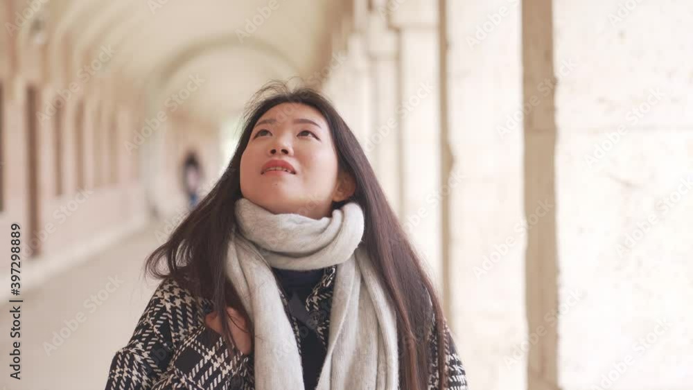 tracking shot on young and beautiful Asian Chinese tourist woman happy enjoying city tour walking around historic area on sunny winter day in holidays travel and tourism tracking shot on young and beautiful Asian Chinese tourist woman happy enjoying city tour walking around historic area on sunny winter day in holidays travel and tourism