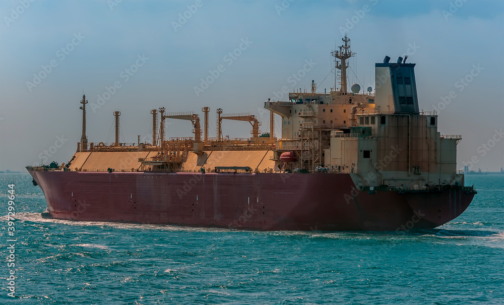 A close up view of a large Liquid Natural Gas tanker ship in the Singapore Straits in Asia in summertime