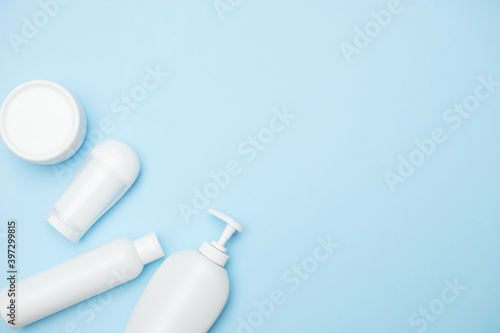 personal hygiene product white jars on a blue background, copy space, top view