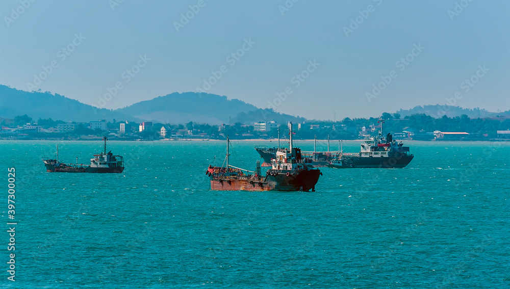 A view of a cluster of small tankers moored offshore in the Singapore Straits in Asia in summertime