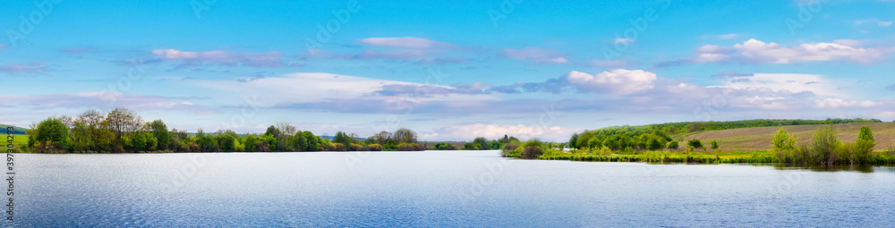 Wide panorama with river and forest in the distance, spring landscape Wide panorama with river and forest in the distance, spring landscape