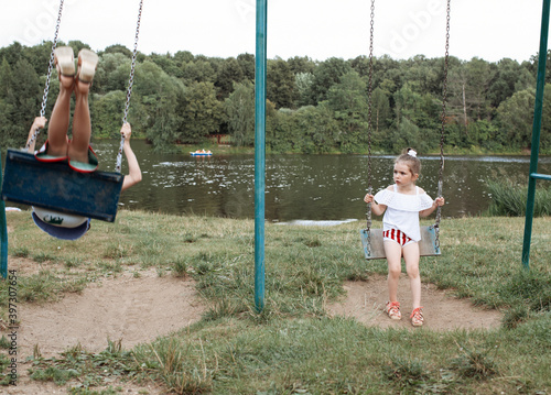 little, cute girl swings on a swing photo