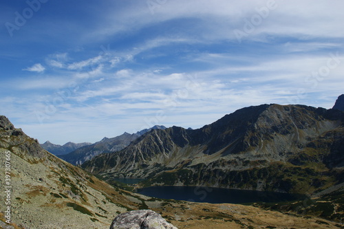 landscape in the High tatra mountains of poland with rocks and a big lake.