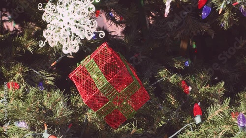 Snowflake And Christmas Present Ornaments Hanging From Christmas Tree