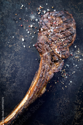 Traditional barbecue wagyu tomahawk beef steak sliced with spice and served as top view on a rustic black board © HLPhoto